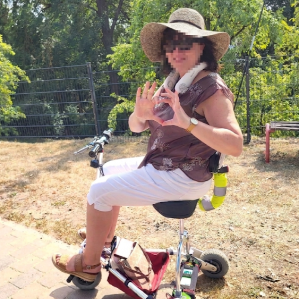 Eine Frau sitzt auf einem elektronisch betriebenen Dreirad.